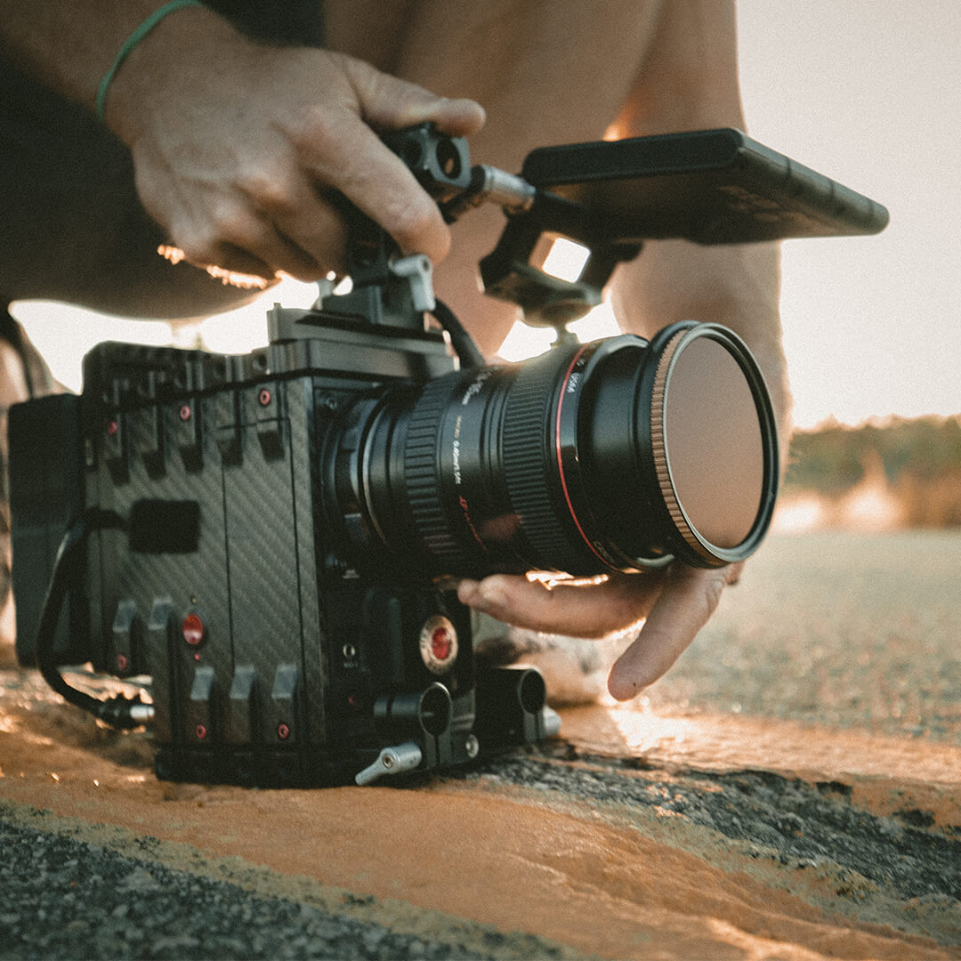 Person holding a film camera low to the ground, adjusting focus - Odgers Executive Search Board Headhunters